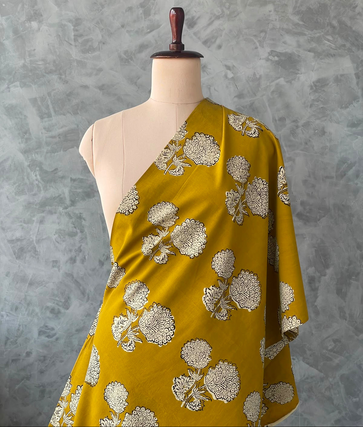 Mustard yellow Jaipur cotton fabric featuring an Ajrakh-inspired print.